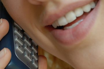 Eine hübsche Frau mit sinnlichen Lippen, spricht in ein Telefon